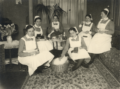 826220 Groepsportret van enkele diaconessen in de huiskamer van het Wijkhuis in de Hendrik van Viandenstraat te ...